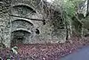 Stone kilns built into a bank with a road in front.