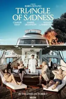 A group of people are seen lounging in a yacht (seen on fire) with the captain standing on a Jacuzzi holding a glass of champagne and a large bottle. Staff members are seen on the background.