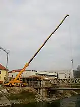 Truck mounted crane building a bridge