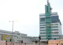 Modern, green-and-white building with dish antennas on top