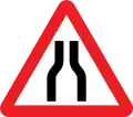 Road narrows on both sides