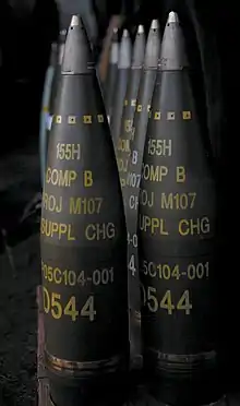 M107 projectiles. All are labelled to indicate a filling of "Comp B" and have fuzes fitted.