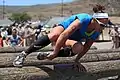 Jasmine Dever hurdles over a set of wooden logs during event 3.