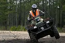 An all-terrain vehicle (ATV) travelling on dirt.