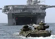 color photo of swimming AAVs approaching the well deck of an amphibious assault ship