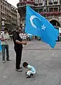 Uyghur man with the Kökbayraq in Munich, Germany