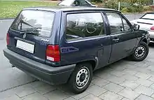  Rear-three quarter view of a small three-door car with flush headlamps.