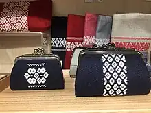 Two small indigo purses decorated with a central stripe of dense white embroidery.