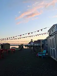 Small shacks along the water front where vendors sell items, although the shacks are closed for the night as the sunsets.