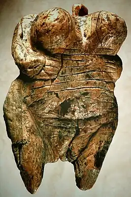 Carving of a female human torso with pronounced breasts