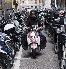 Rider looking for a place at parking lot in Trieste, where use of a scooter in city transport is among highest in Italy.[citation needed]