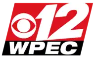 Two slanted boxes, one red and one thinner and black. In the red box, a white CBS eye and a skewed numeral 12. In the black box, the letters W P E C in an extended sans serif in white.