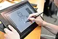 A person drawing on a Cintiq tablet.