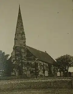 Black and white photograph of the church of St John, the steeple prominent against the sky