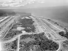 An aerial photo of two parallel airstrips with a body of water at the right