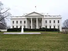 A north side view of the White House, showing the main building and the water feature in front of it