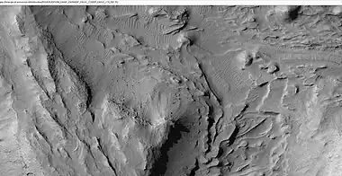 Mound showing layers at the base, as seen by HiRISE under HiWish program.  Location is east of Gale Crater in the Aeolis quadrangle.