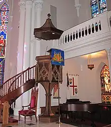 The "wine glass" pulpit and sounding board of 1872 survived the fire of 1965