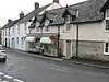 Street scene, showing shops and houses including a post office.