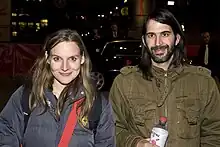 Holofernes and Roy standing outside in front of cars