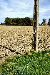 An intact Stokes shell found during the iron harvest in 2004 near Ypres and placed on a telegraph pole for collection and disposal