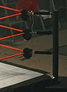 Padded turnbuckles in a wrestling ring connecting ring ropes to post