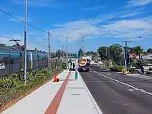 A bus interchange on the right with a bus and railway tracks on the left with a train