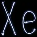 Illuminated violet gas discharge tubes shaped as letters X and e