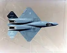 Top view of black jet aircraft, showing trapezoidal wings, engine nozzle, and two-piece tail. The separation between the forward fuselage and engine nacelles is apparent.