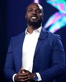 A man smiling towards something to the left of the camera.