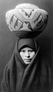 A girl from the Zuni tribe of New Mexico with a painted pottery jar, photographed in c. 1903.